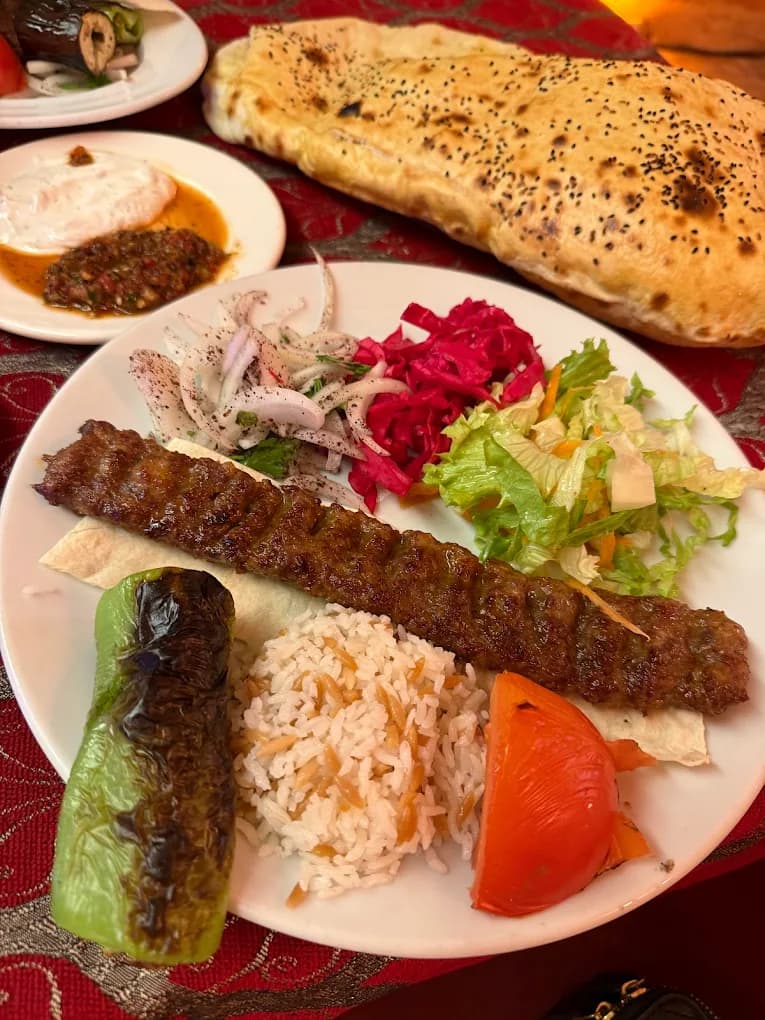 Gegrillter türkischer Kebab-Teller mit traditionellen Beilagen