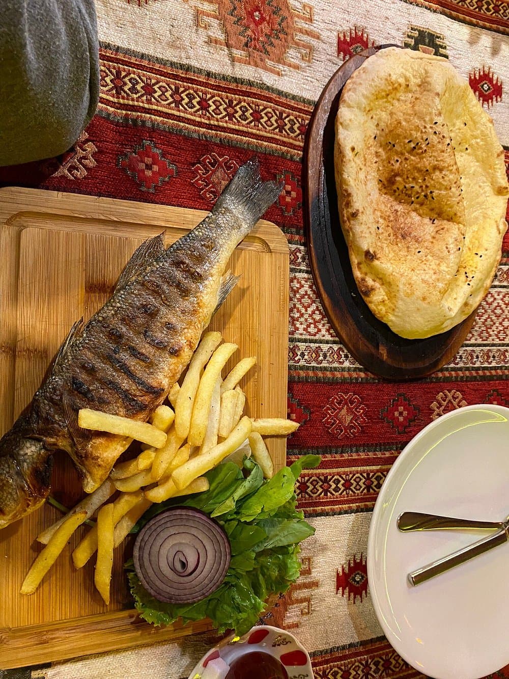 Limon ve yeşilliklerle servis edilen ızgara levrek